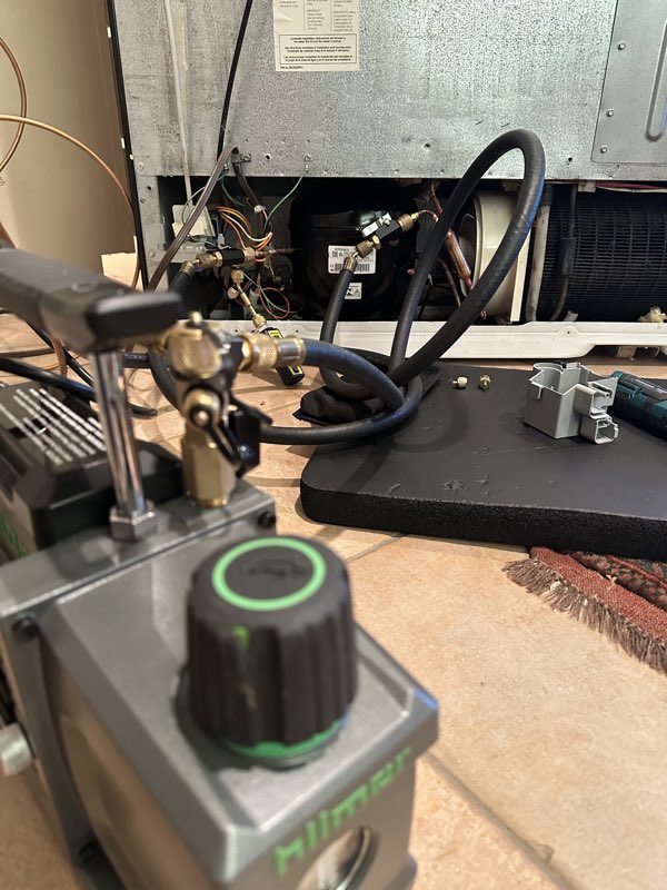 New GE Profile refrigerator compressor connected to manifold gauges during the nitrogen pressure and leak test